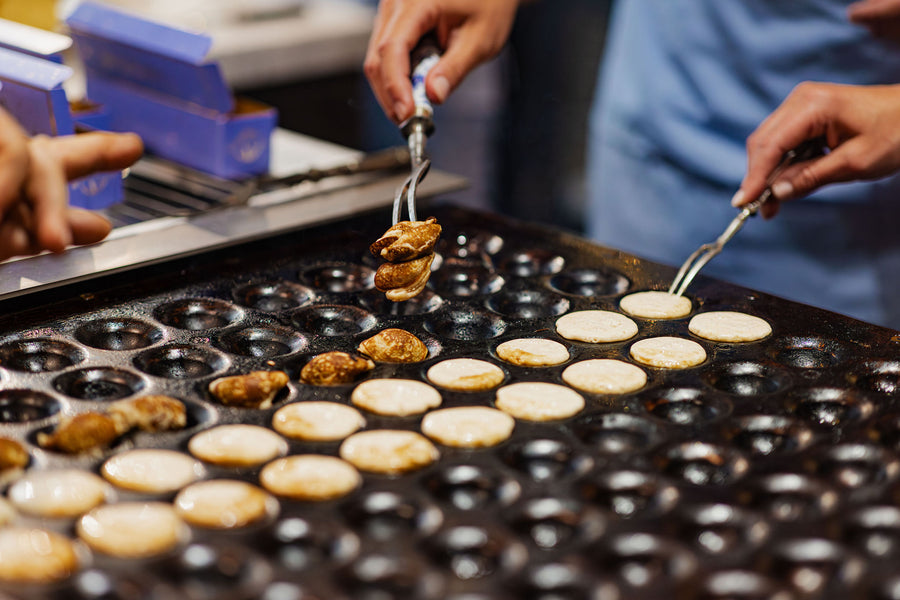 Poffertjes worden gekeerd op de poffertjesplaat bij Vonckelend